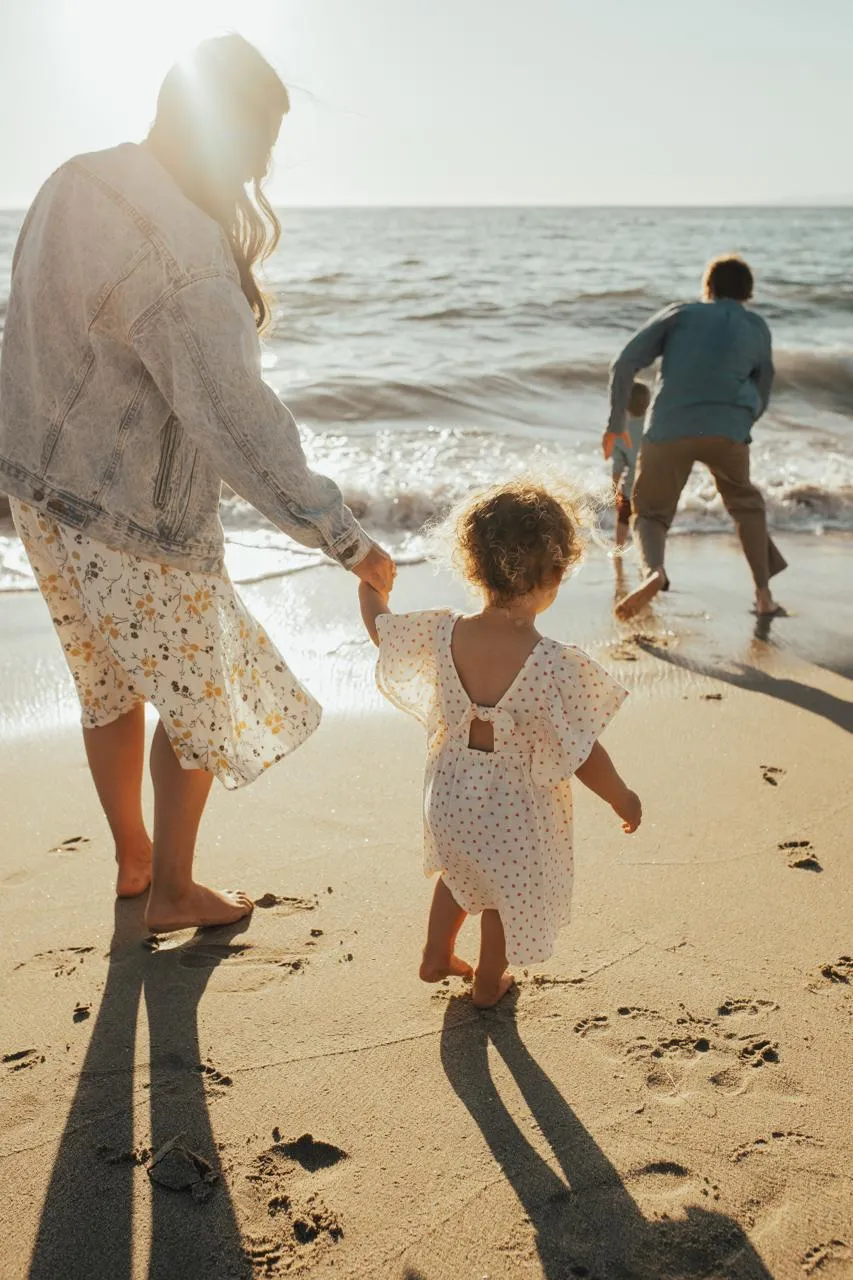 Jade, her husband, and their two kids walking into the waves together