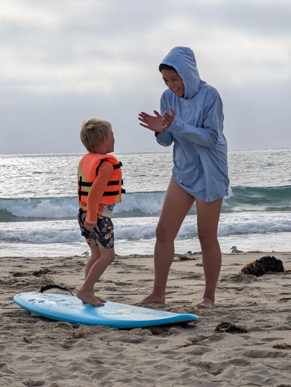 Jade cheering her son on during a surf lesson at the beach
